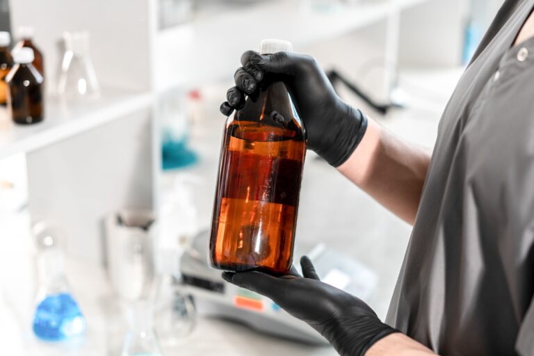 Transparante jerrycan gevuld met industriële GBL-reiniger met de tekst 'GBL KOPEN BELGIË' op het etiket.